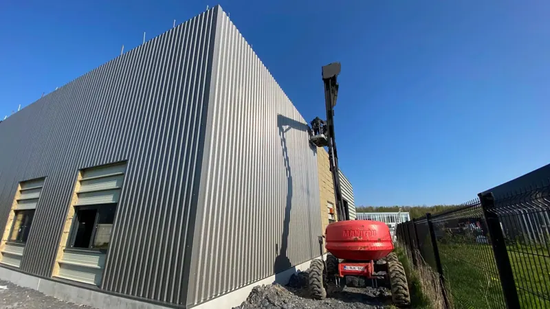 Bâtiment en cours de bardage, nacelle en façade