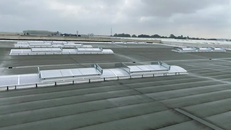 Grande toiture industrielle en cours d'étanchéité, lanterneaux en place